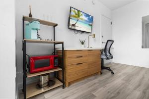 an office with a desk with a microwave and a red microwave at Modern New Studio Balcony & Pool in Hallandale Beach