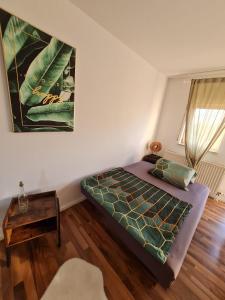 a bedroom with a bed and a table at Mels Apartment in Schwetzingen