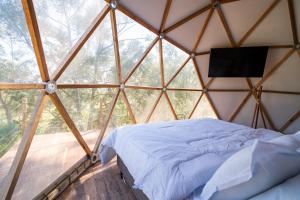 a room with a bed and a television in a yurt at Monakó Cabanas in Bragança Paulista