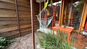 a porch with a hammock on the side of a house at Encino House Hotel & Glamping Valle de Bravo in Valle de Bravo