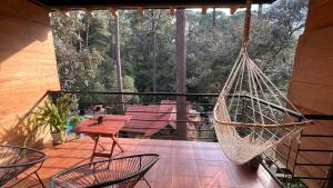 a hammock on a deck with a table and chairs at Encino House Hotel & Glamping Valle de Bravo in Valle de Bravo +111 photos