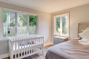 a white crib in a bedroom with windows at 9 Mi to National Mall Spacious Bethesda Retreat! in Bethesda