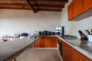 a kitchen with wooden cabinets and a counter top at Casa Kahu by Wynwood House in Los Órganos