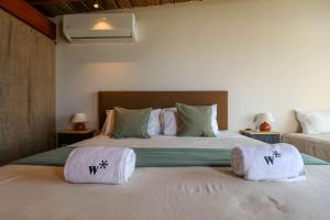 a bedroom with two beds with towels on them at Casa Kahu by Wynwood House in Los Órganos