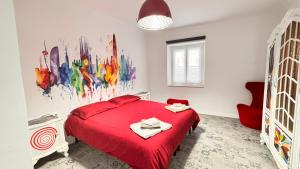 a bedroom with a red bed and a painting on the wall at Estilenuevo Fashion Rooms in Druento