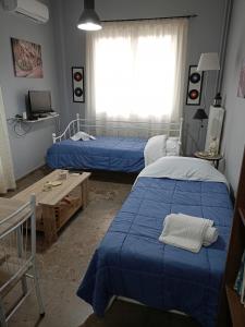 a bedroom with two beds and a window at ELENI's House-Near the Old Railway Station in Nafplio