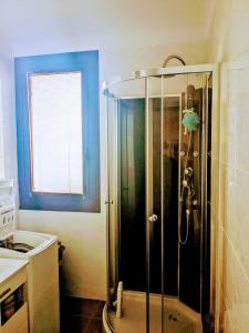 y baño con ducha y pared azul. en T2 Vue mer à 15 min de Collioure, en Banyuls-sur-Mer