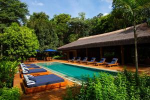 a swimming pool with lounge chairs and a resort at Fazenda Shanti in Alto Paraíso de Goiás