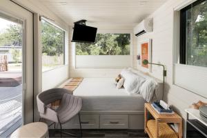 a bedroom in a tiny house with a bed and a tv at ParcBlu in Fredericksburg +90 photos