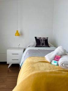 a bedroom with a bed with a yellow blanket at Casa YASA con parque privado y parrilla in El Calafate