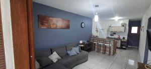 a living room with a couch and a kitchen at Casa aconchegante em nova tramandai centro in Tramandaí