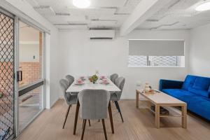 a living room with a table and a blue couch at Tranquil Retreat Ideal Loc in Brisbane