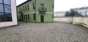 an empty courtyard of a green building at Apartament Chłodna 14 in Suwałki