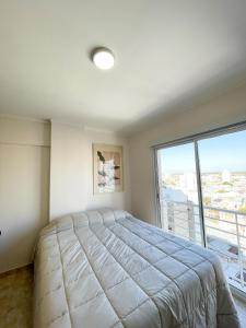 布兰卡港Saavedra 118 5°B by depptö的一间卧室，配有一张大床和一扇大窗户。