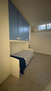 a bedroom with a bed in a room with blue cabinets at Sweet Home in Santa Marinella