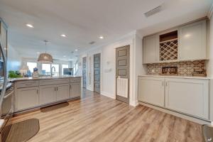 a large kitchen with white cabinets and a wooden floor at Luxury Family Beach Front Property! Family Oriented! Gulf Views! in Panama City Beach