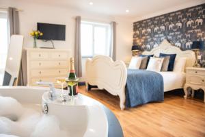 a bedroom with a bed and a sink and a tub at The Paddocks Cottage in Westward Ho