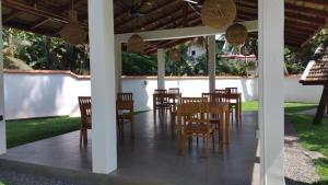 a dining room with tables and chairs under a pavilion at Surfn'Chill Kabalana in Ahangama
