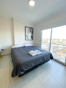 a bedroom with a bed with two towels on it at Saavedra 118 6°B by depptö in Bahía Blanca