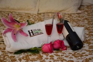Hotel Elvita Spa في بانوس: طاولة مع كأسين من النبيذ والزهور