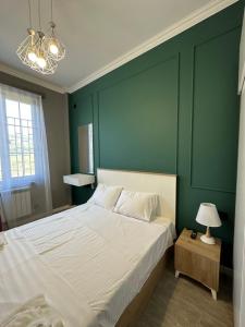 a bedroom with a large bed with a green wall at Dili Hill in Dilijan