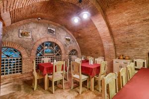 comedor con mesa roja y sillas en Liva Hotel, en Tiflis