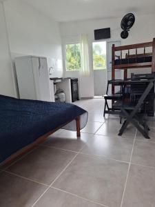 a living room with a bed and a table in it at Casa da Maria Ubatuba in Ubatuba