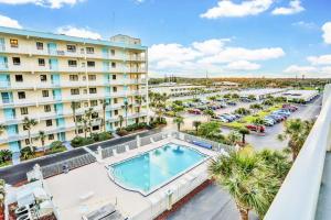 an aerial view of a hotel with a swimming pool and a parking lot at Sandcastles 2br2ba Cocoa Beach Ocean Views! in Cocoa Beach