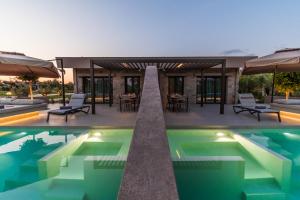 a villa with a swimming pool and a patio at Nestor Luxury Villas in Romanu