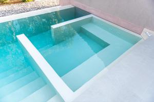 a swimming pool with blue water inside of it at Nestor Luxury Villas in Romanu