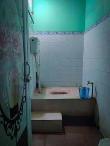 GājolRisabya Guest House的房间里有带浴缸的浴室