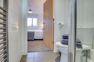 ein kleines Badezimmer mit Toilette und ein Schlafzimmer in der Unterkunft Stay Yorkshire Hamilton Mews Apartment in Doncaster + 19 Fotos