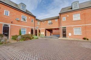 ein Backsteingebäude mit einer Einfahrt davor in der Unterkunft Stay Yorkshire Hamilton Mews Apartment in Doncaster