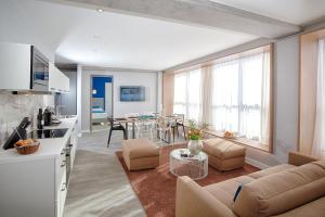 - un salon avec un canapé et une salle à manger dans l'établissement MLOFT Apartments München, à Munich