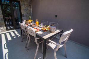 a dining room table with chairs and food on it at Nestor Luxury Villas in Romanu