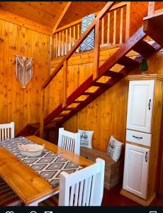 ein Esszimmer aus Holz mit Tisch und Treppe in der Unterkunft Estancia Vieja in Estancia Vieja