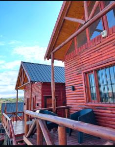eine Blockhütte mit einer Veranda und einer Holzterrasse in der Unterkunft Estancia Vieja in Estancia Vieja + 4 Fotos
