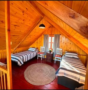 zwei Betten in einem Zimmer in einer Blockhütte in der Unterkunft Estancia Vieja in Estancia Vieja