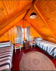 Zimmer im Dachgeschoss mit 2 Betten und einem Teppich in der Unterkunft Estancia Vieja in Estancia Vieja