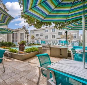 a patio with a table and chairs and an umbrella at Resort Style Apt/Home in Houston Medical Centre in Houston