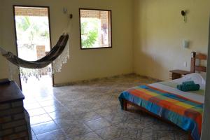 Habitación con cama y hamaca. en Pousada Oceania en Taíba