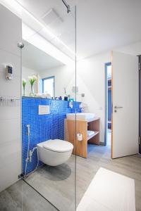a bathroom with a toilet and a glass shower at MLOFT Apartments München in Munich