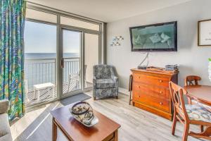 a living room with a table and a dresser with a window at Remodeled Condo with Hot Tub in N Myrtle Beach! in Myrtle Beach