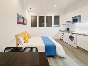 a white bedroom with a bed and a washing machine at Bilbao ROOMS & KITCHEN Irala in Bilbao