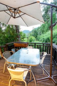 a table and chairs on a deck with an umbrella at Huequecura Explorer in Quilaco