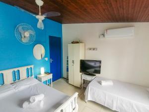 Camera blu con 2 letti e una TV di Casa 12 Búzios Vilas a 500m da Rua das Pedras, top localização em condomínio lindo e calmo, portaria 24h a Búzios