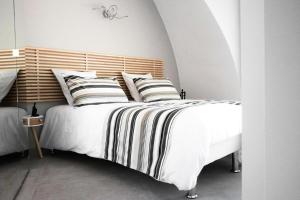 a bedroom with a large white bed with striped pillows at Gîte de France Game of dome - Gîte de France 4 personnes MAE-4601 in Chartrier-Ferrière