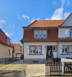 ein weißes Haus mit einem Zaun davor in der Unterkunft Maison cosy et bien située in Colmar