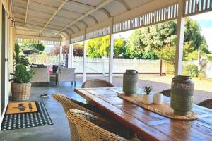 a porch with a wooden table and chairs at Bakery Cottage Moyhu in Moyhu