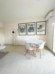 a dining room with a white table and chairs at Saavedra 118 6ºI by depptö in Bahía Blanca